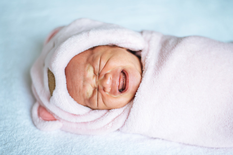newborn-baby-wrapped-soft-pink-blanket-crying